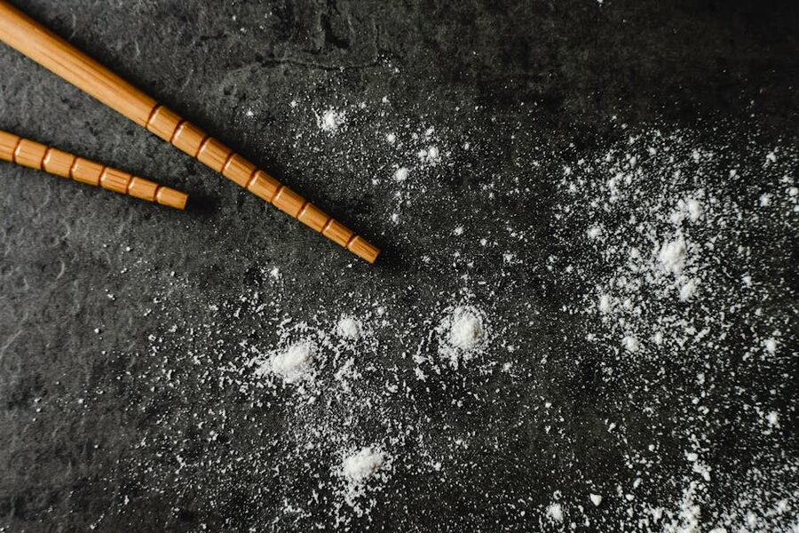 Brown chopsticks arranged on dark surface with fine dust