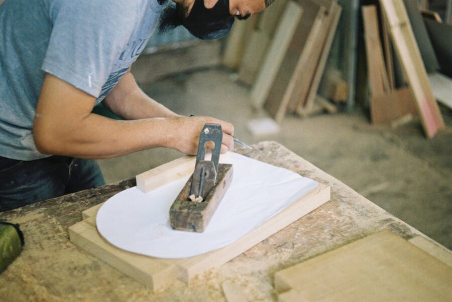 Carpenter using a hand plane to smooth wood