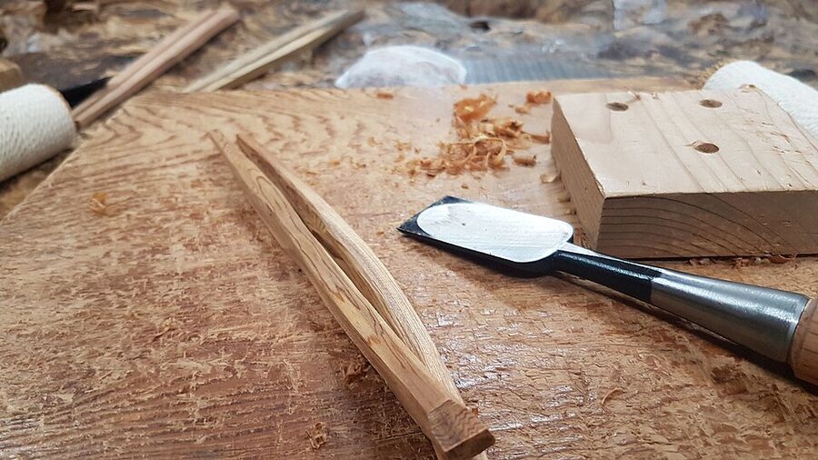Tools used for traditional chopstick making laid out on a wooden surface