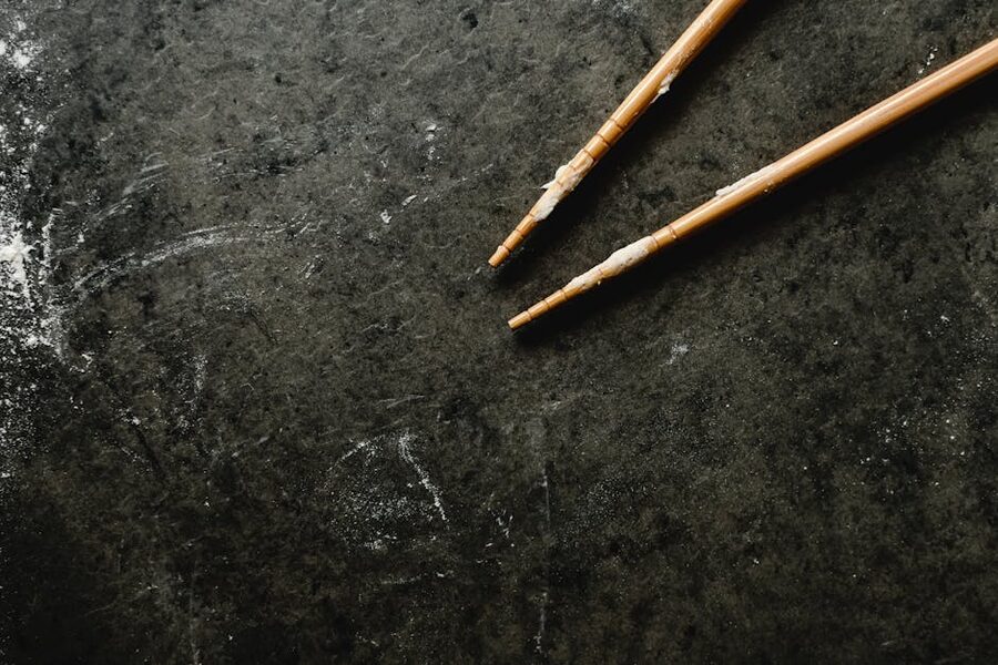 Wooden chopstick blanks resting on a dark workshop surface