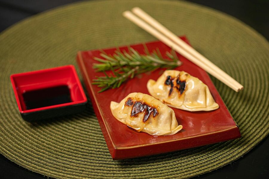 Gyoza dumplings with soy sauce on a red plate