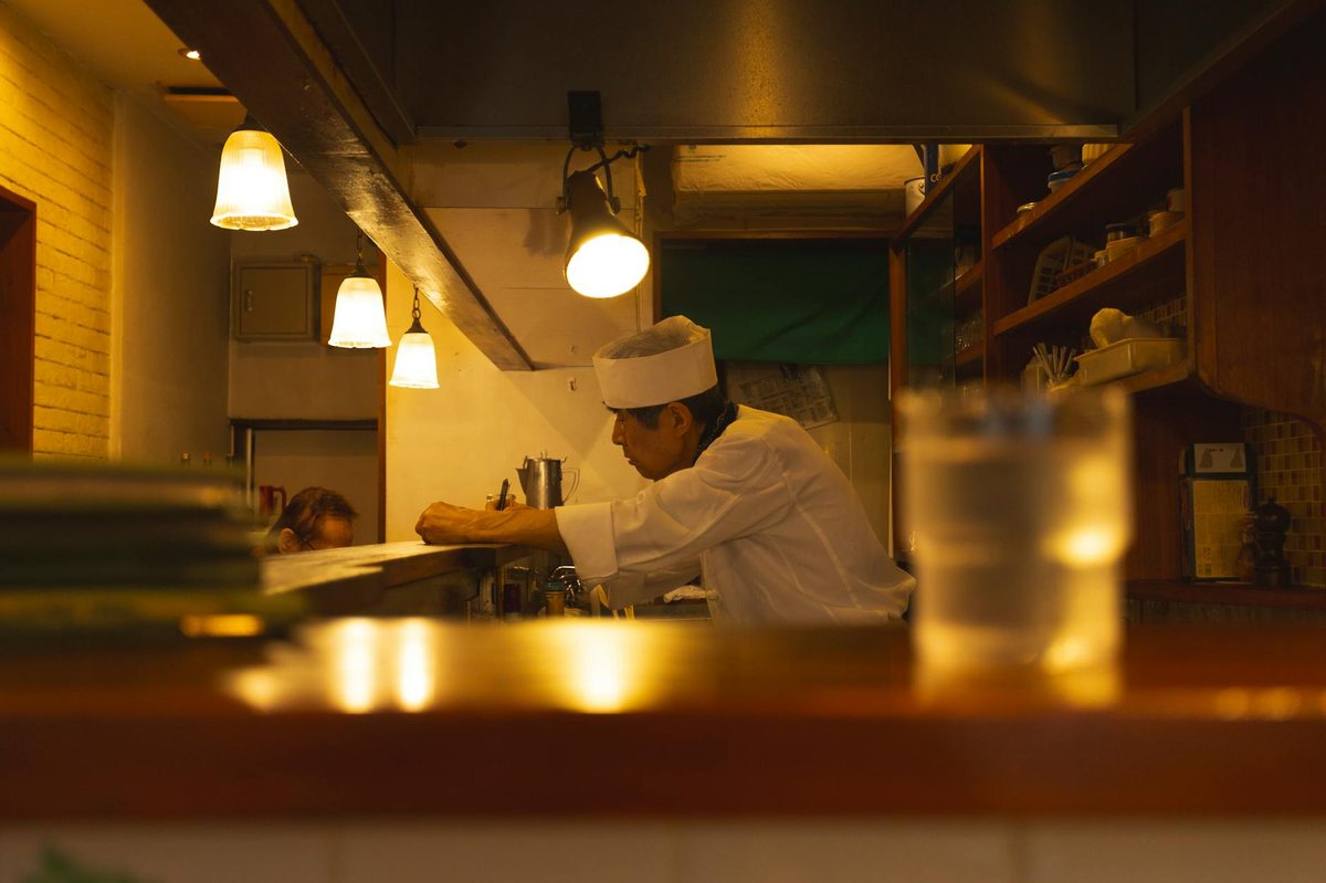 Japanese chef preparing a dish in a cozy Tokyo restaurant