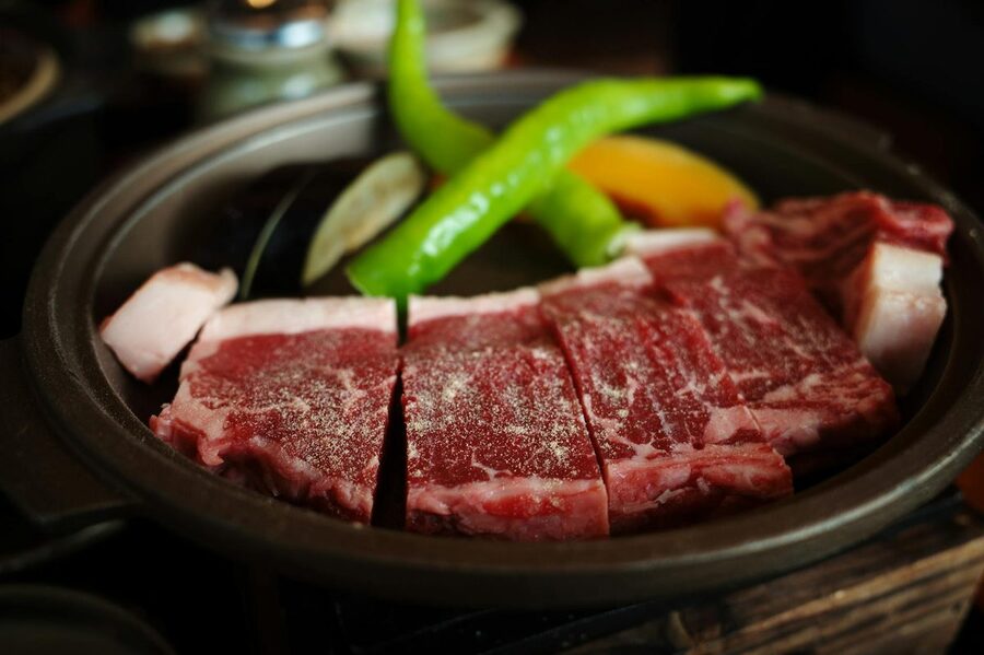 Marbled wagyu beef with green peppers in Japanese cookware