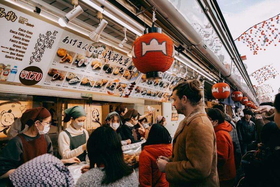 Tokyo street food market with people under lanterns