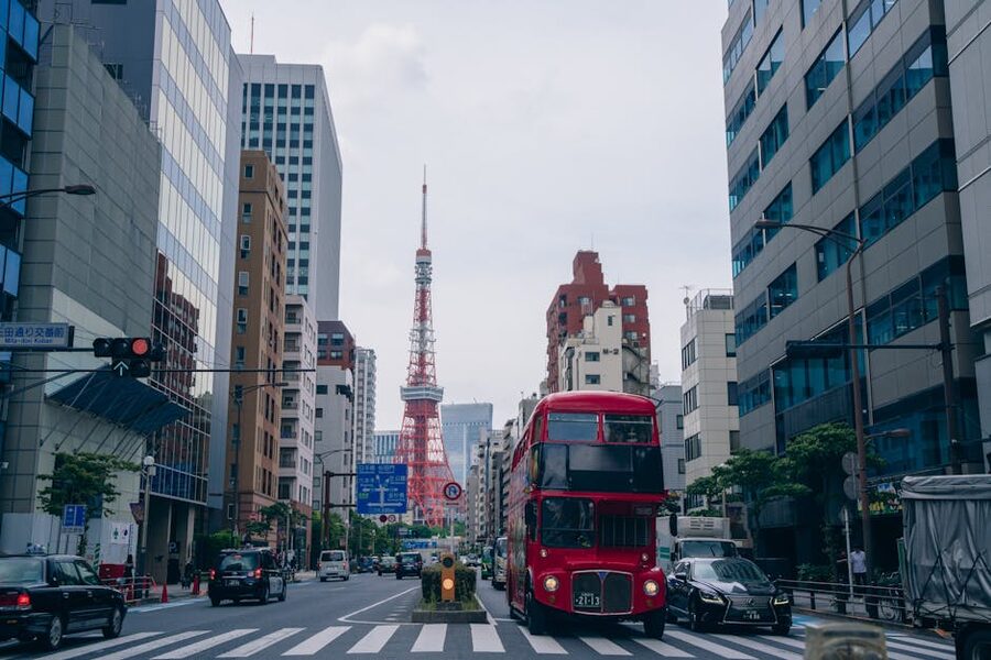 Red Sky Hop double-decker bus rolling past Tokyo Tower
