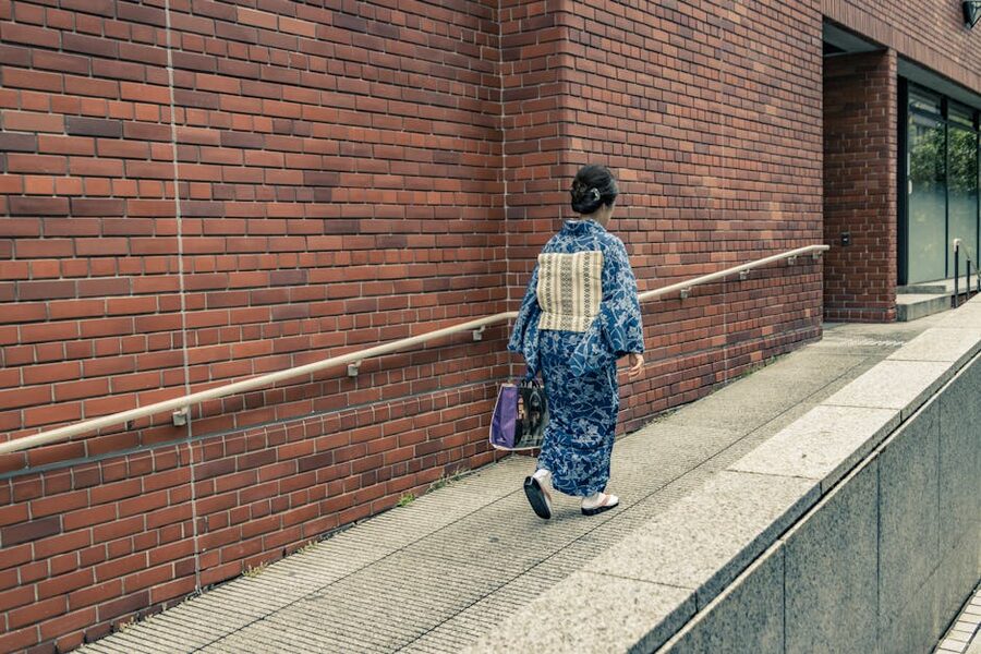 Woman in blue kimono walking along a Tokyo street