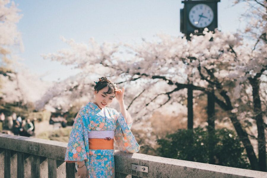 Woman in kimono on a bridge surrounded by cherry blossoms in Tokyo