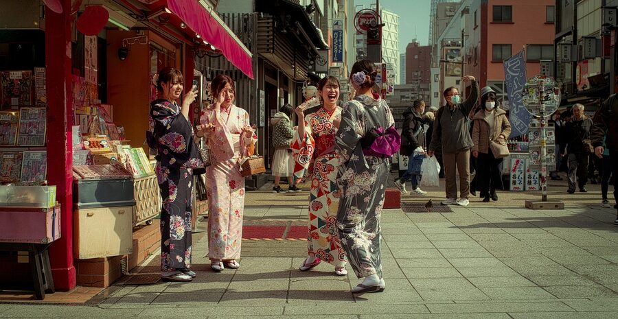 Friends in kimonos laughing together on a Tokyo street
