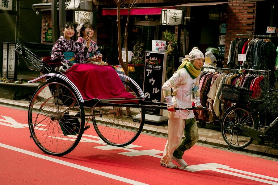 Woman in kimono riding a rickshaw through Tokyo