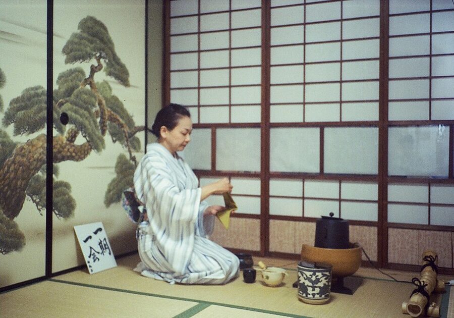 A tea ceremony host preparing matcha in a tatami tearoom