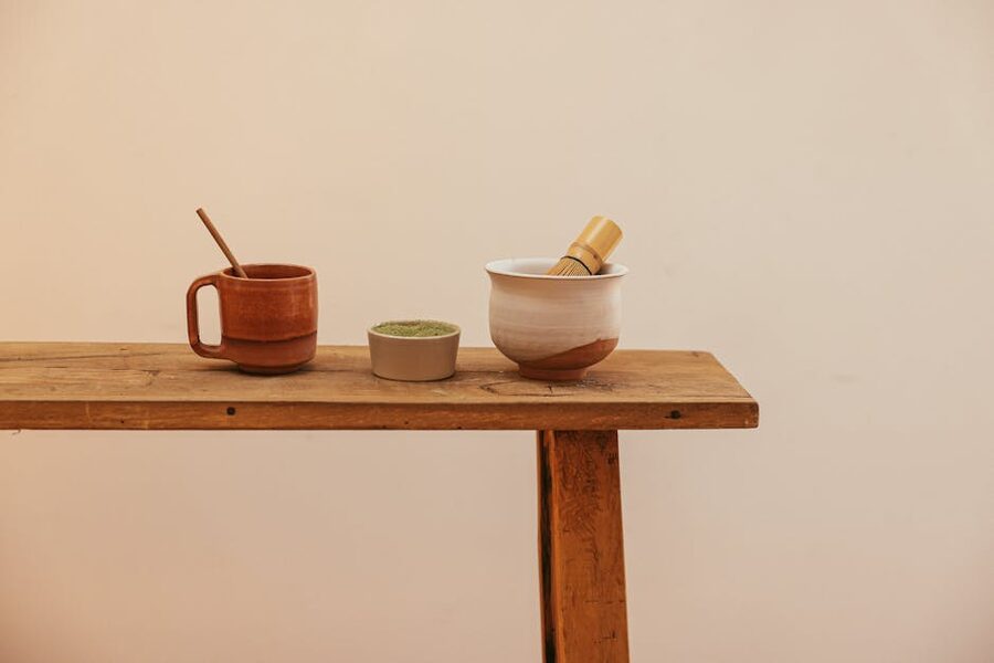 Matcha powder and tea ceremony materials laid out on a wooden bench