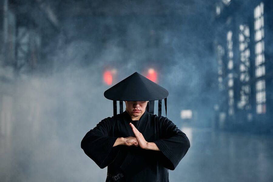 Ninja in conical hat and black robes performing a training stance
