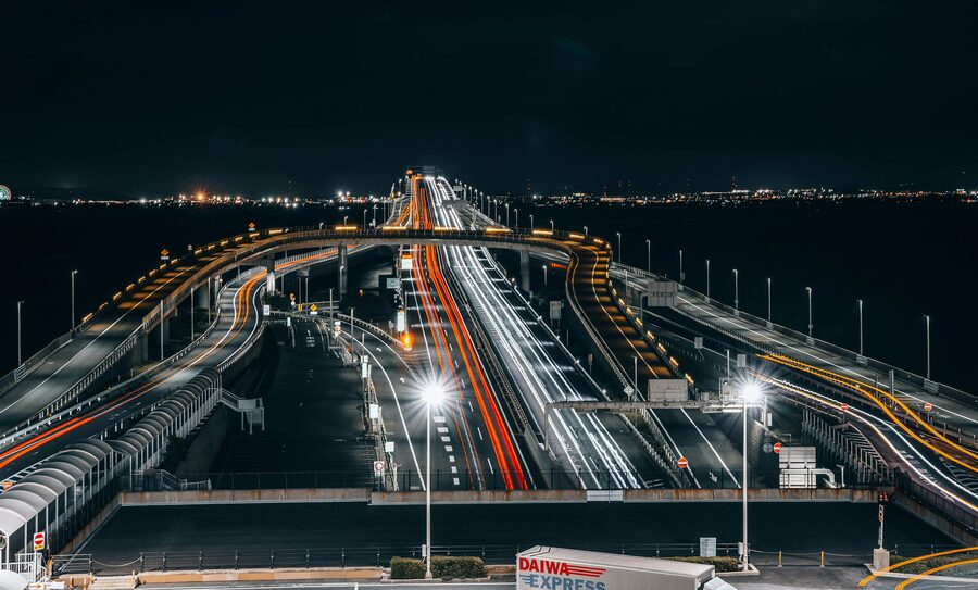 Long exposure photograph of Rainbow Bridge in Tokyo showing vehicle light trails