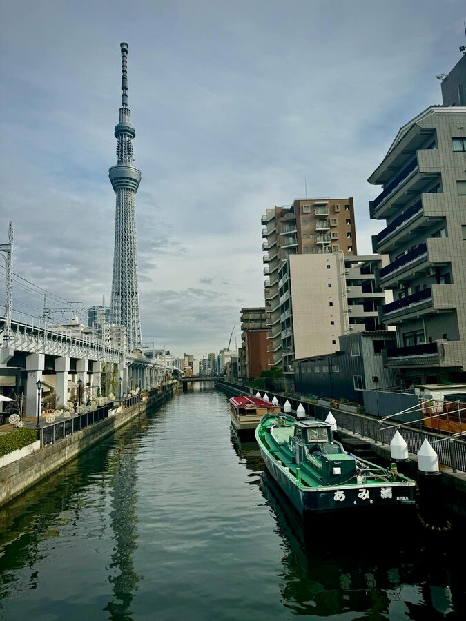 Scenic view of Tokyo Skytree with riverboats along the Sumida River