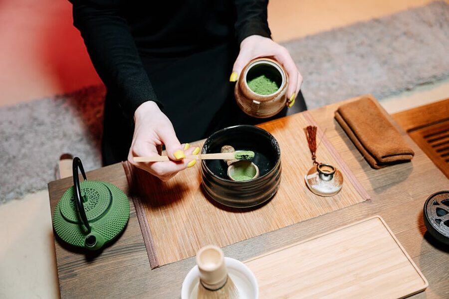 Hands whisking matcha in a chawan tea bowl