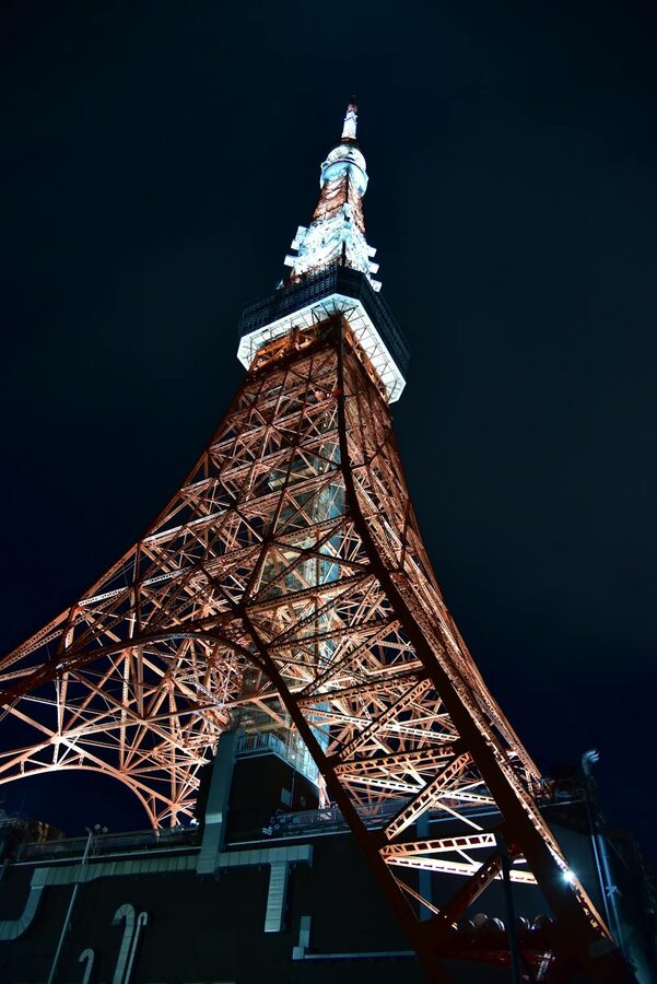 Distant view of Tokyo Tower lit up against the night sky