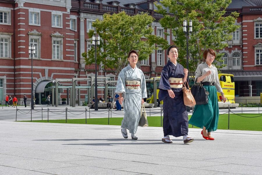 Three people in traditional attire walking outside Tokyo Station