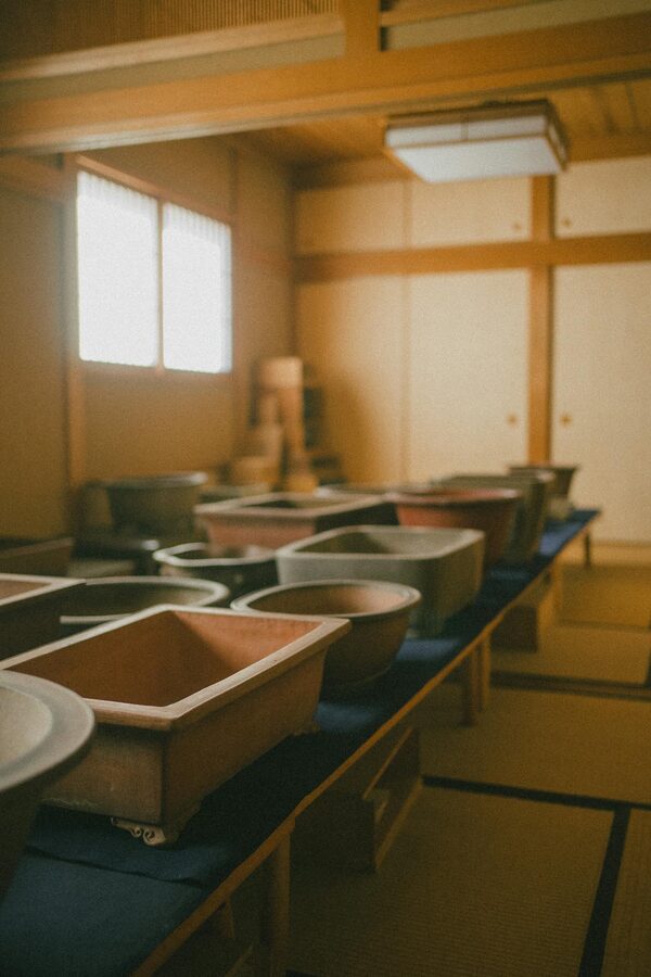 Warm-toned Japanese workshop with pottery on tatami mats