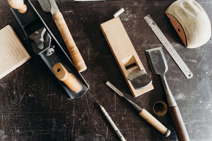 A collection of various woodworking tools arranged on a workshop table showcasing craftsmanship essentials