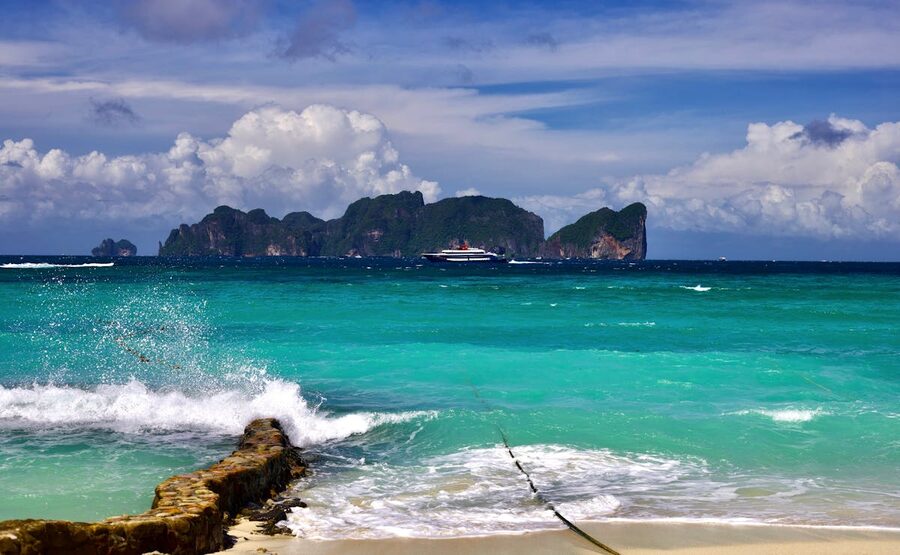 Tropical beach with turquoise water and distant island under clear sky