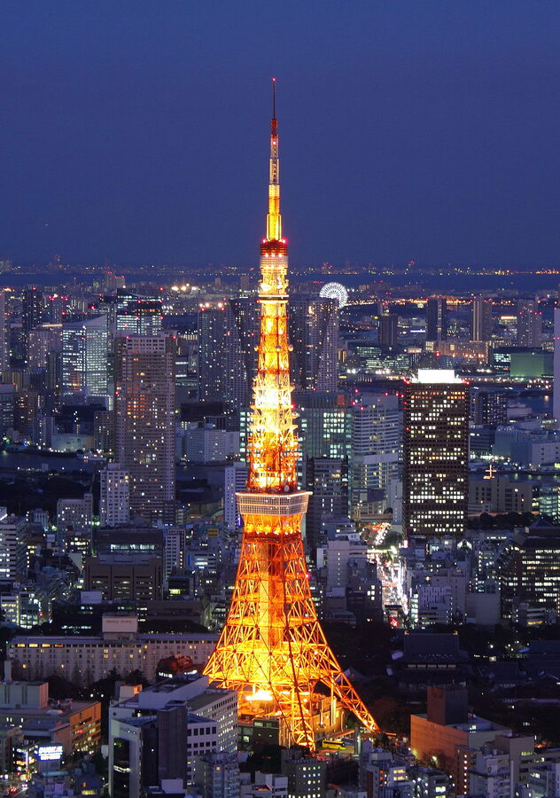 Tokyo Tower illuminated at night with warm orange glow against dark sky