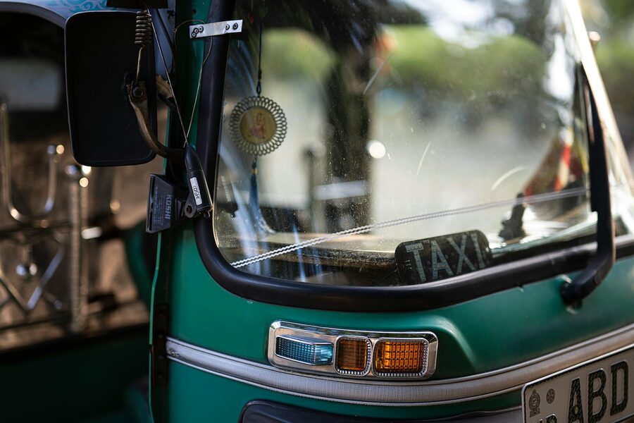 Close-up of a green tuk-tuk showing the windshield and details in Colombo