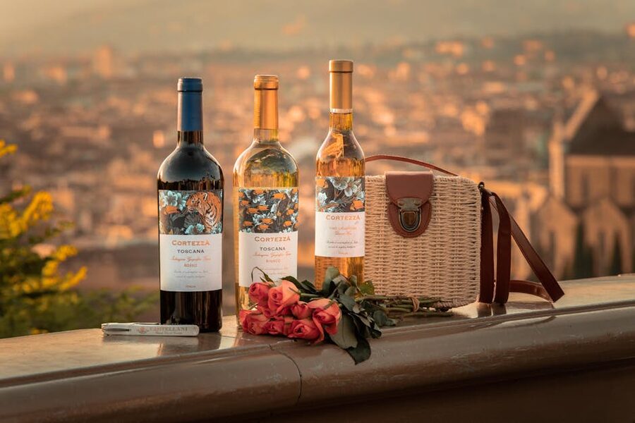 Wine bottles with roses and Tuscan town backdrop