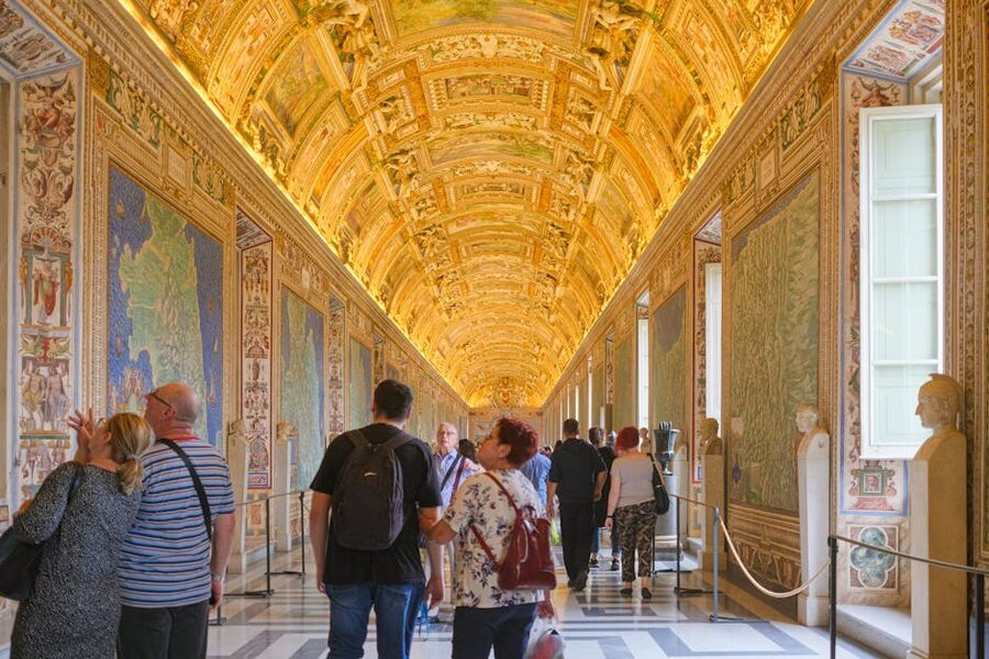 Long frescoed corridor inside the Vatican Museums leading toward the Sistine Chapel