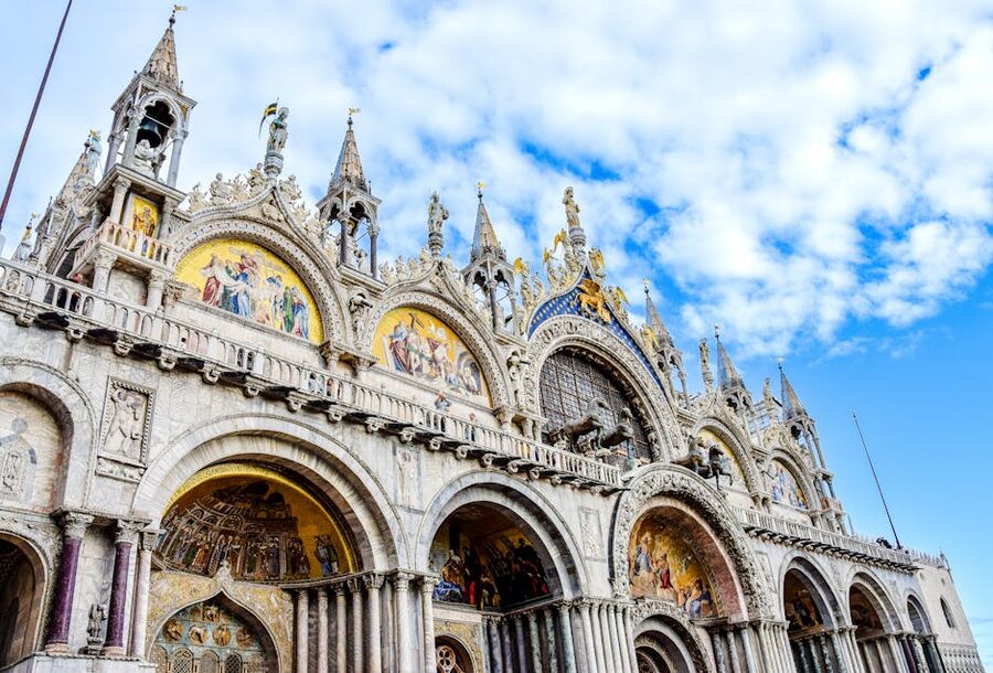 Low angle view of St Mark's Basilica ornate facade against blue sky