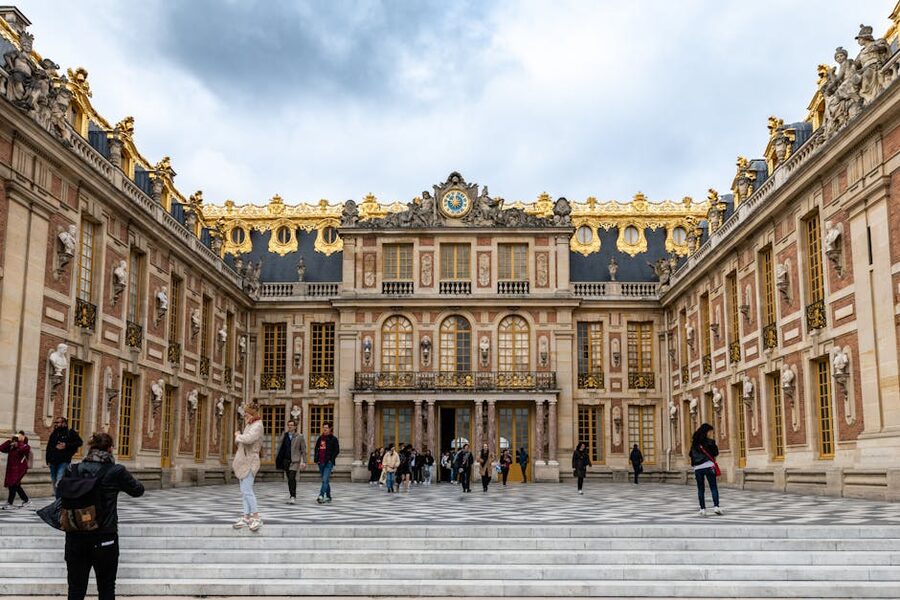 People walking in front of Versailles palace
