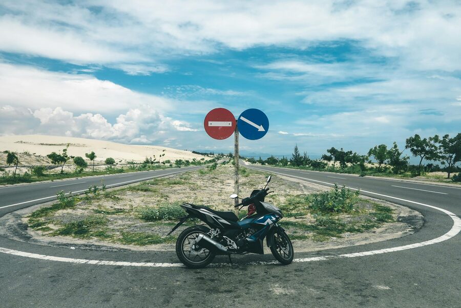 Small motorbike climbing a curving mountain road in northern Vietnam highlands