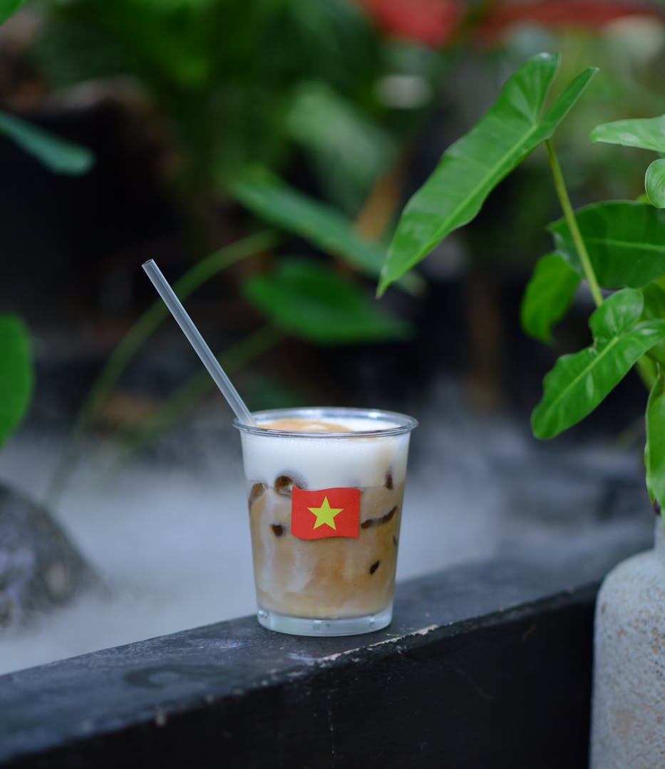 Vietnamese coffee being brewed in a traditional phin filter over a glass of condensed milk