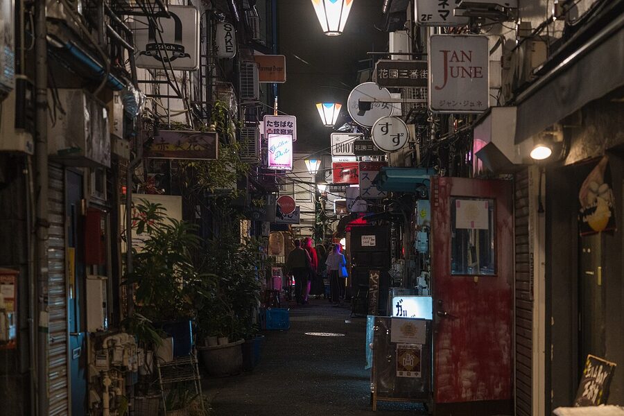 Narrow alley of Golden Gai bars at night with warm lantern lighting in Shinjuku