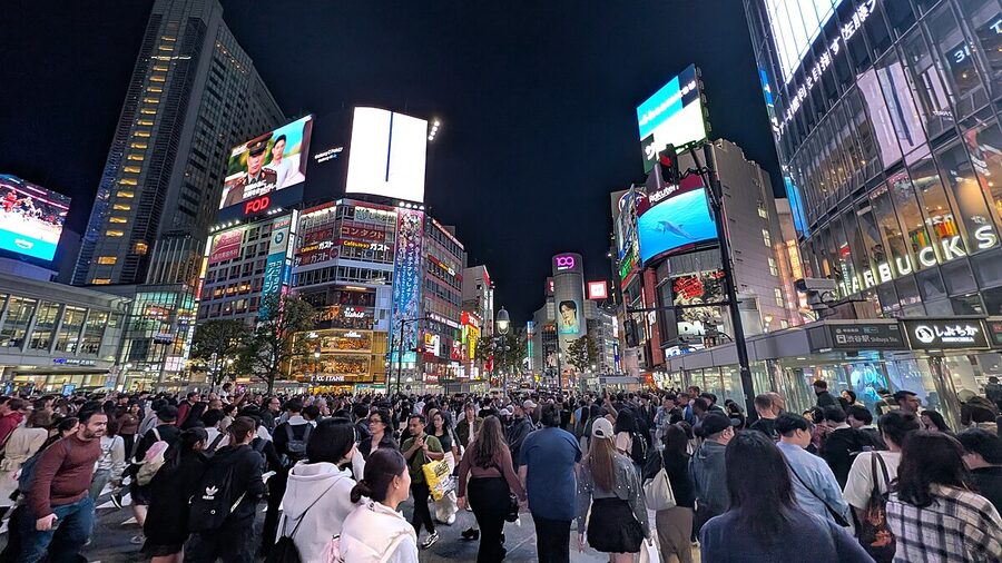 Shibuya Scramble Crossing at night with bright lights and crowds of people