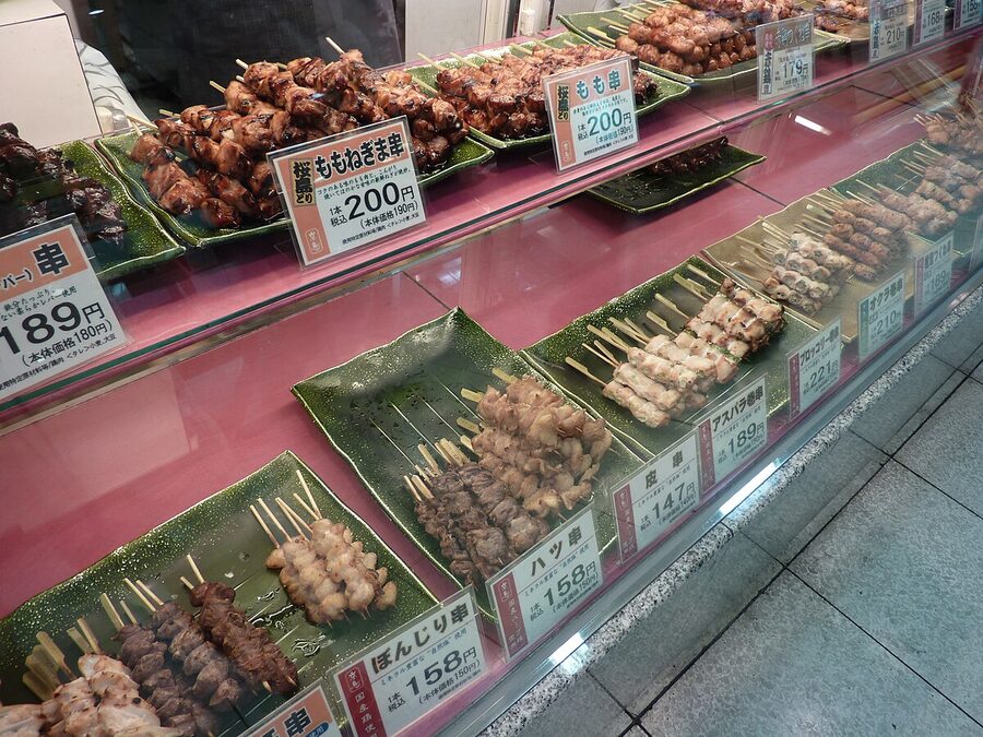 Close-up of yakitori chicken skewers being grilled over charcoal