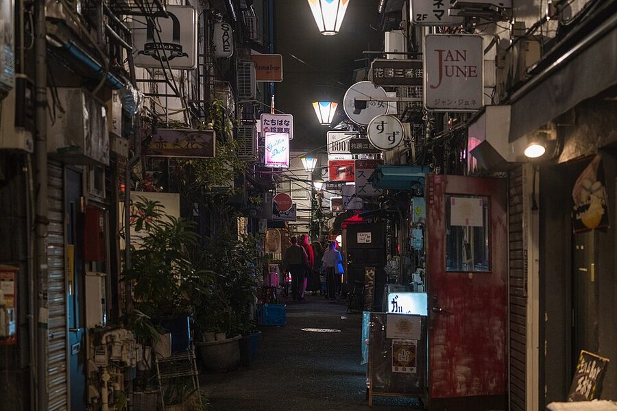 Shinjuku Golden Gai narrow alley lit up at night with bar signs and low rooflines