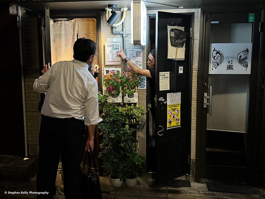 Inside Golden Gai narrow Shinjuku alley showing tiny bars with hand-painted signs