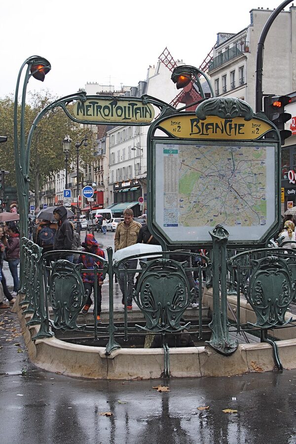 Place Blanche metro entrance with Moulin Rouge in the background Paris