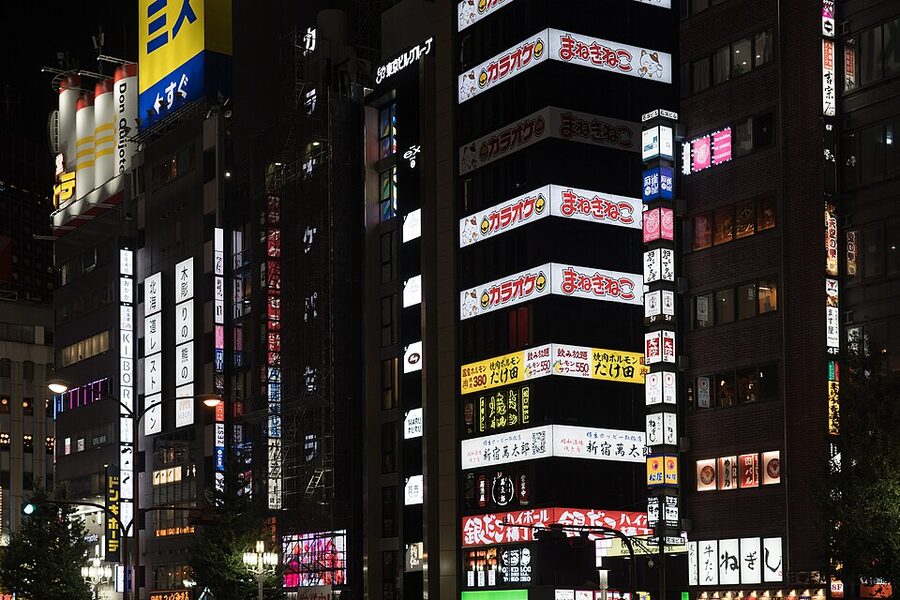 Shinjuku streets at night with neon signs and crowds of visitors
