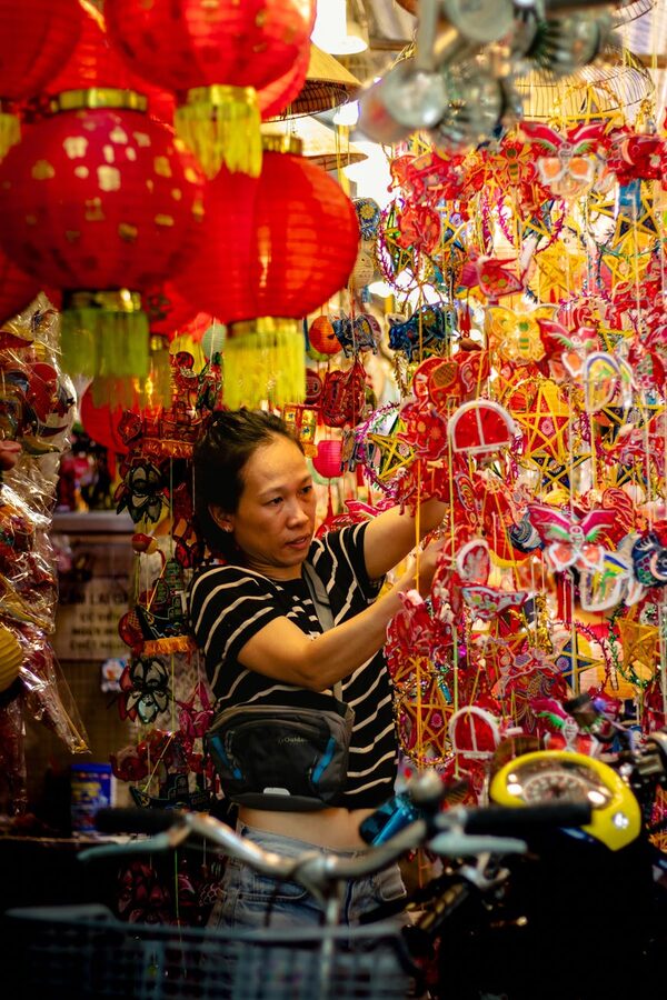 Woman selecting lanterns at a market in Vietnam