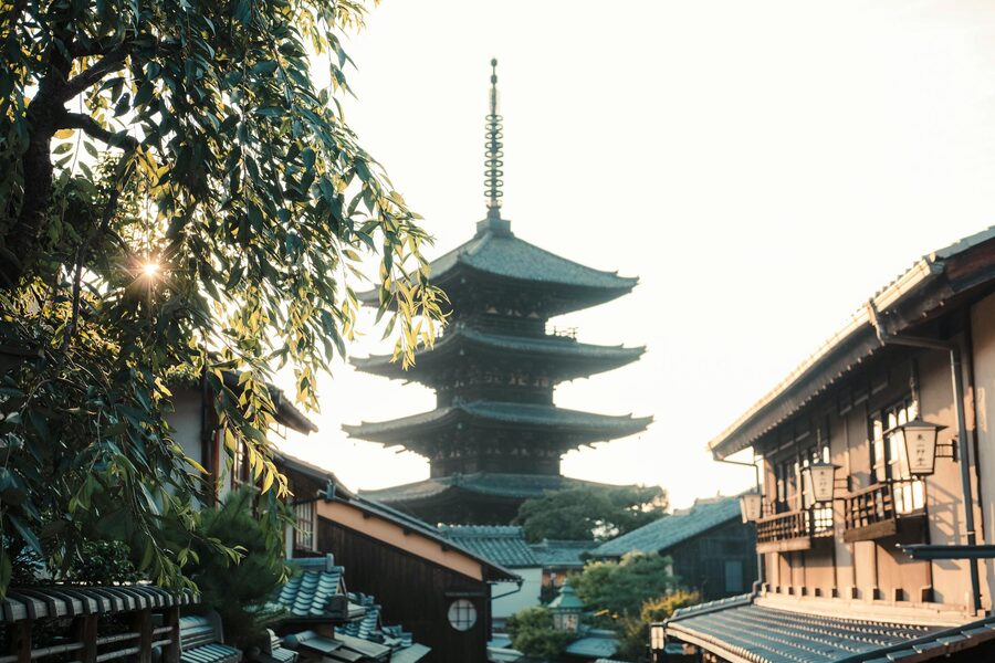 Sunlight filtering through trees near Yasaka Pagoda in Kyoto at dawn