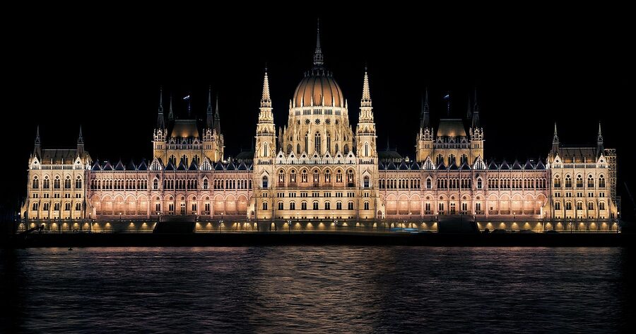 Parliament Building lit in the evening reflected in the Danube