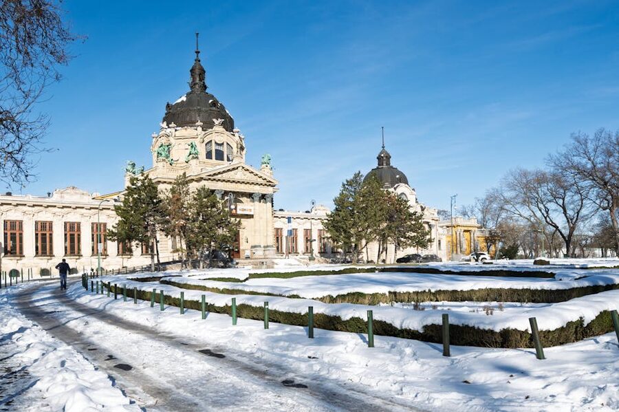 Snow-covered Széchenyi Thermal Bath in winter under blue sky