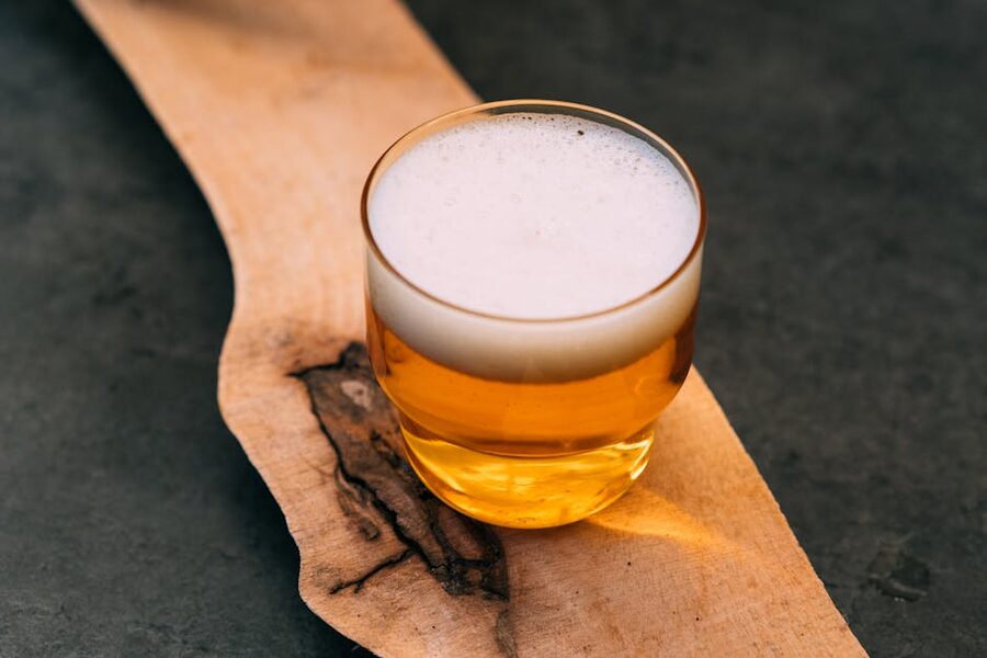 Small glass of Koelsch beer with foam on a wooden table