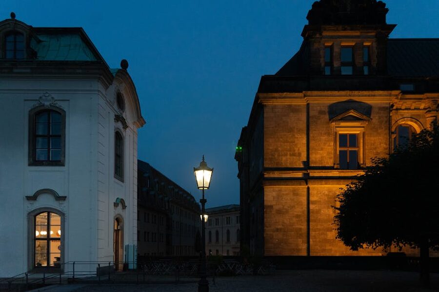 Dresden street at dusk with glowing streetlamp and historic buildings