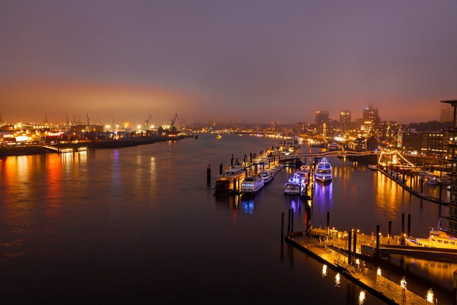Hamburg harbor illuminated at night with boats