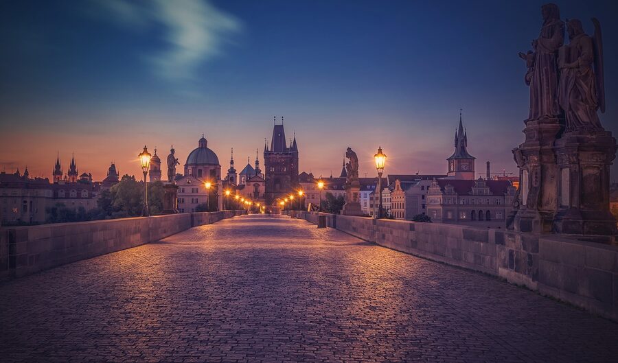 Stone statues lining Charles Bridge in Prague at night