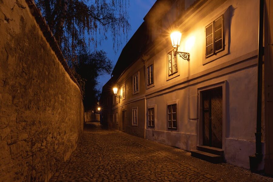 Illuminated cobblestone lane in Prague Old Town after dark