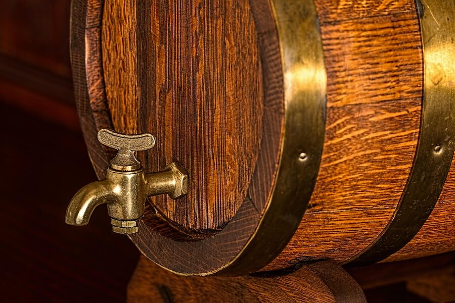 Wooden beer barrel keg in a brewery cellar with brass tap