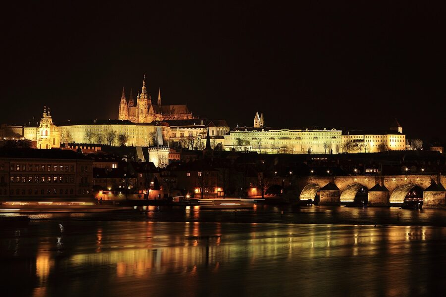 Prague Old Town rooftops with city lights at night